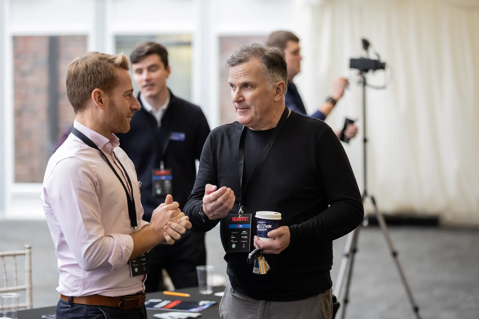 Two delegates in conversation during a networking break at IGNITE! 26