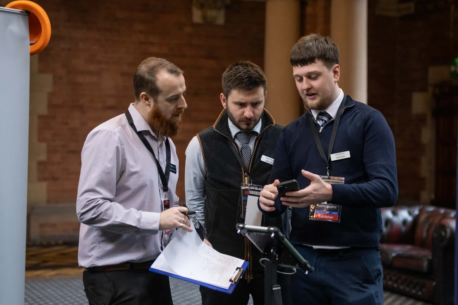 Exhibitors speaking with a delegate at a stand at IGNITE! 26